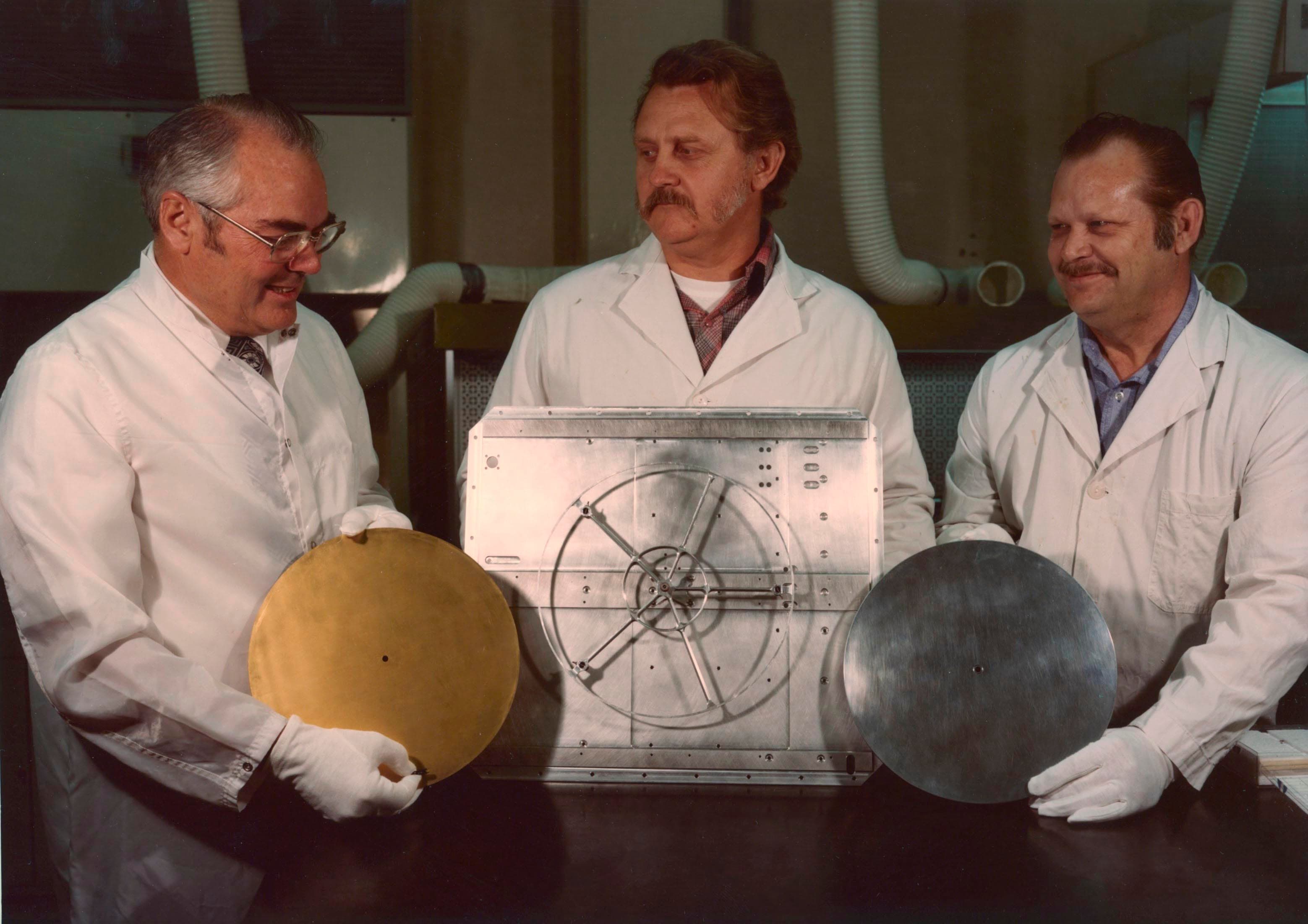 Three members of the Voyager record team holding the record components